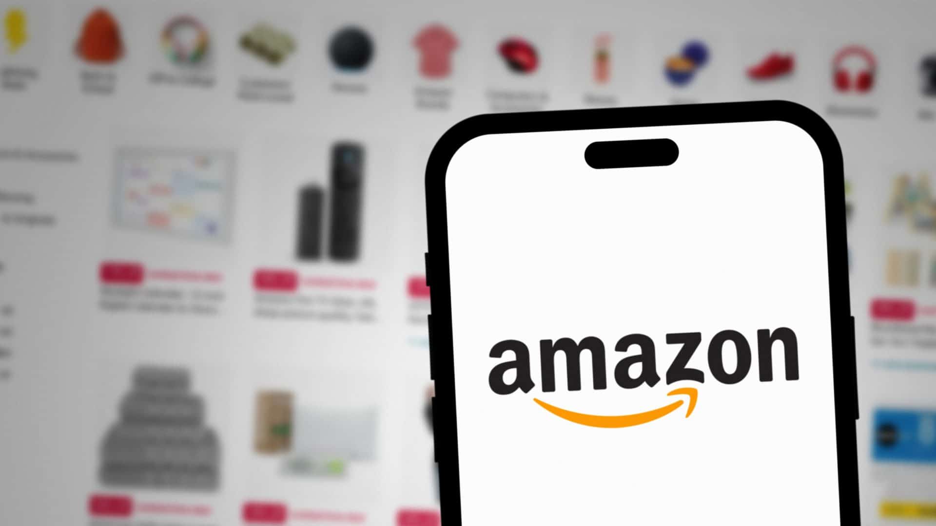 iPhone com logotipo da Amazon na tela e, ao fundo, página de ofertas de produtos na Amazon