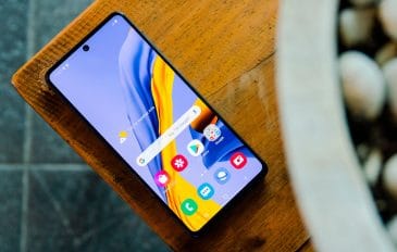 Celular Samsung Galaxy M51 em cima de mesa de madeira com tela acesa na tela inicial