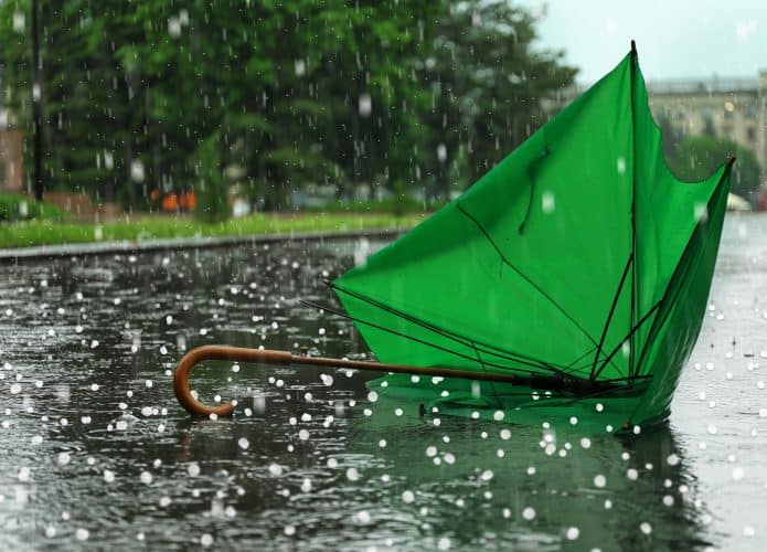 Granizo e um guarda-chuva verde quebrado no chão