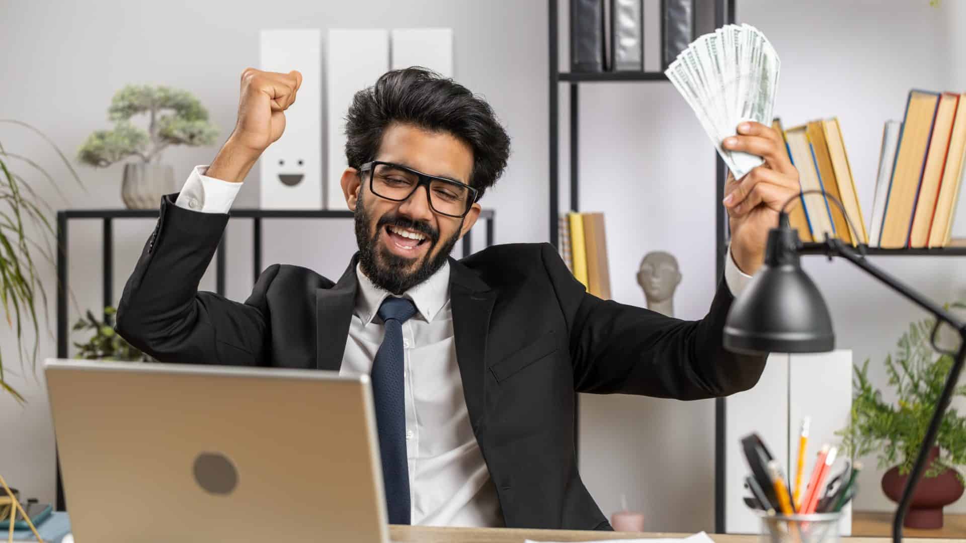 Homem com notas de dólar comemorando