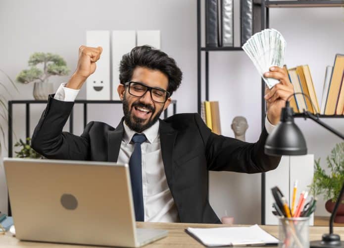 Homem com notas de dólar comemorando
