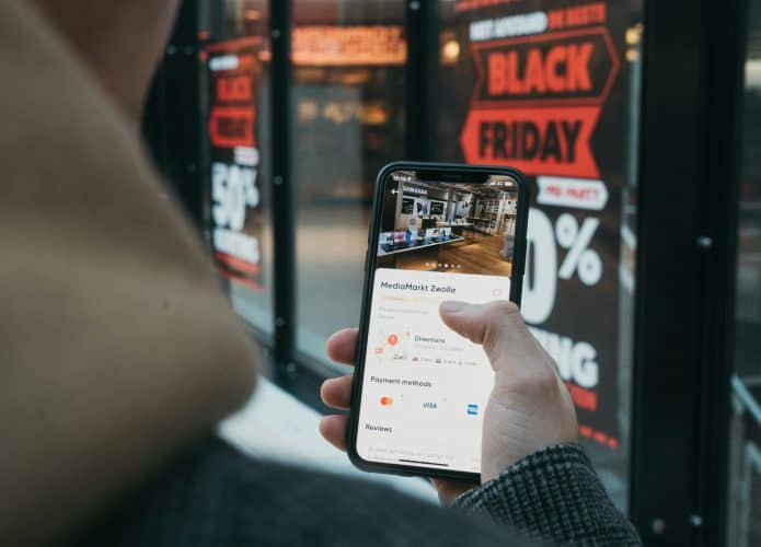 Homem olhando anúncio online de eletrônicos durante a Black Friday