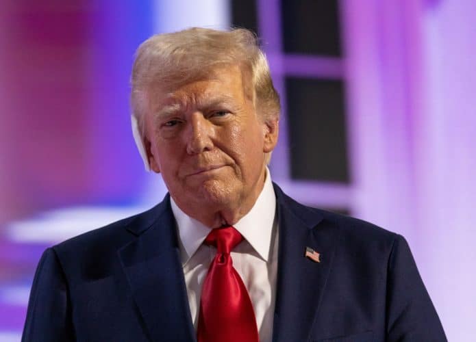 Donald Trump de terno e olhando ligeiramente para o lado