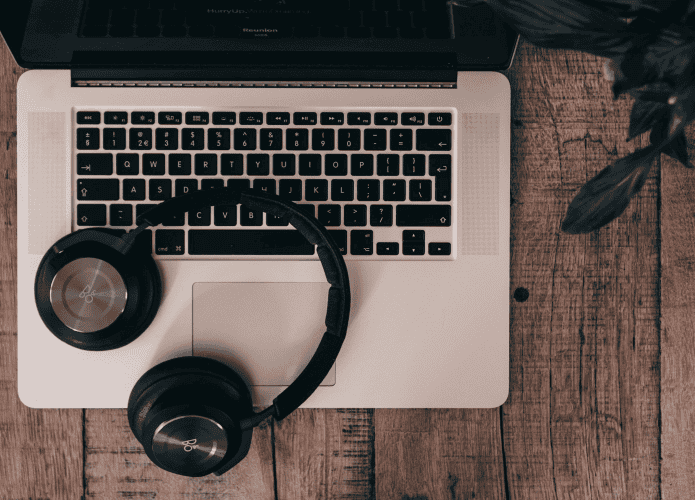 imagem mostra um Fone de ouvido Bluetooth em cima de um notebook