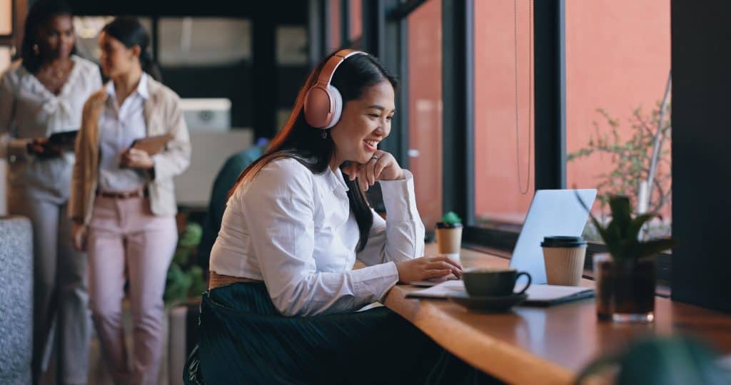 Mulher trabalha em café pelo computador (vaga remota)