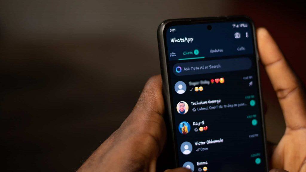 Pessoa segurando celular com WhatsApp aberto