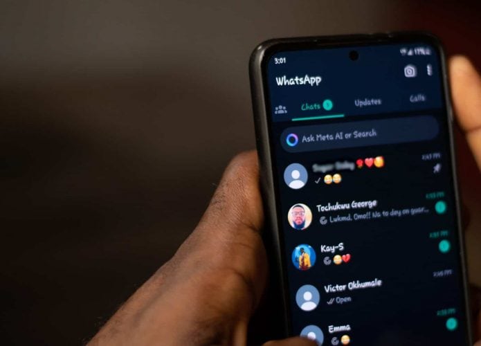 Pessoa segurando celular com WhatsApp aberto