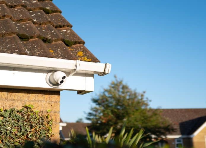 Câmera de CCTV de cor dia e noite do tipo cúpula recém-instalada, fixada nas beiradas de um bungalow privado. Uma de várias câmeras para monitorar um beco sem saída.