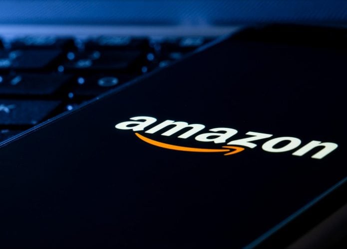 Celular com logomarca da Amazon na tela colocado em cima de teclado de computador