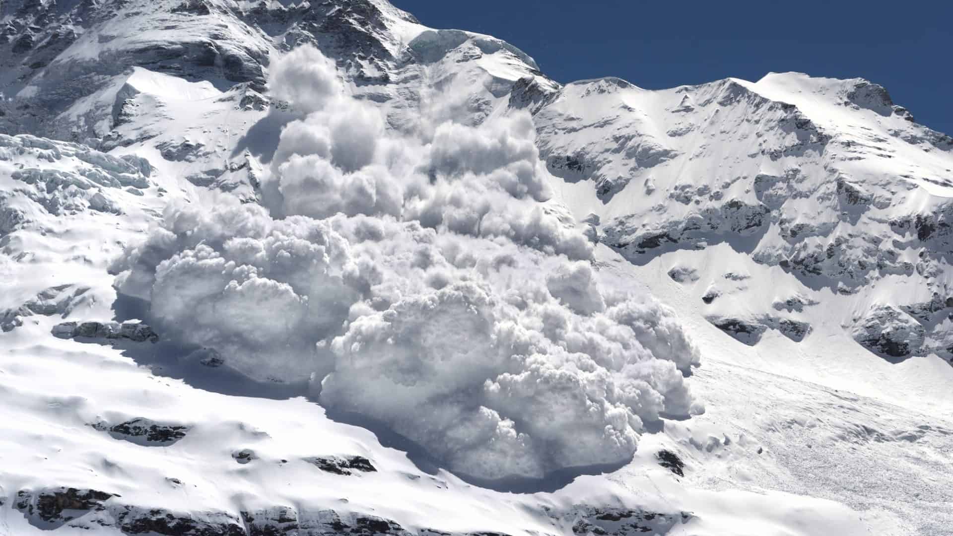 Uma avalanche está descendo uma encosta íngreme da montanha