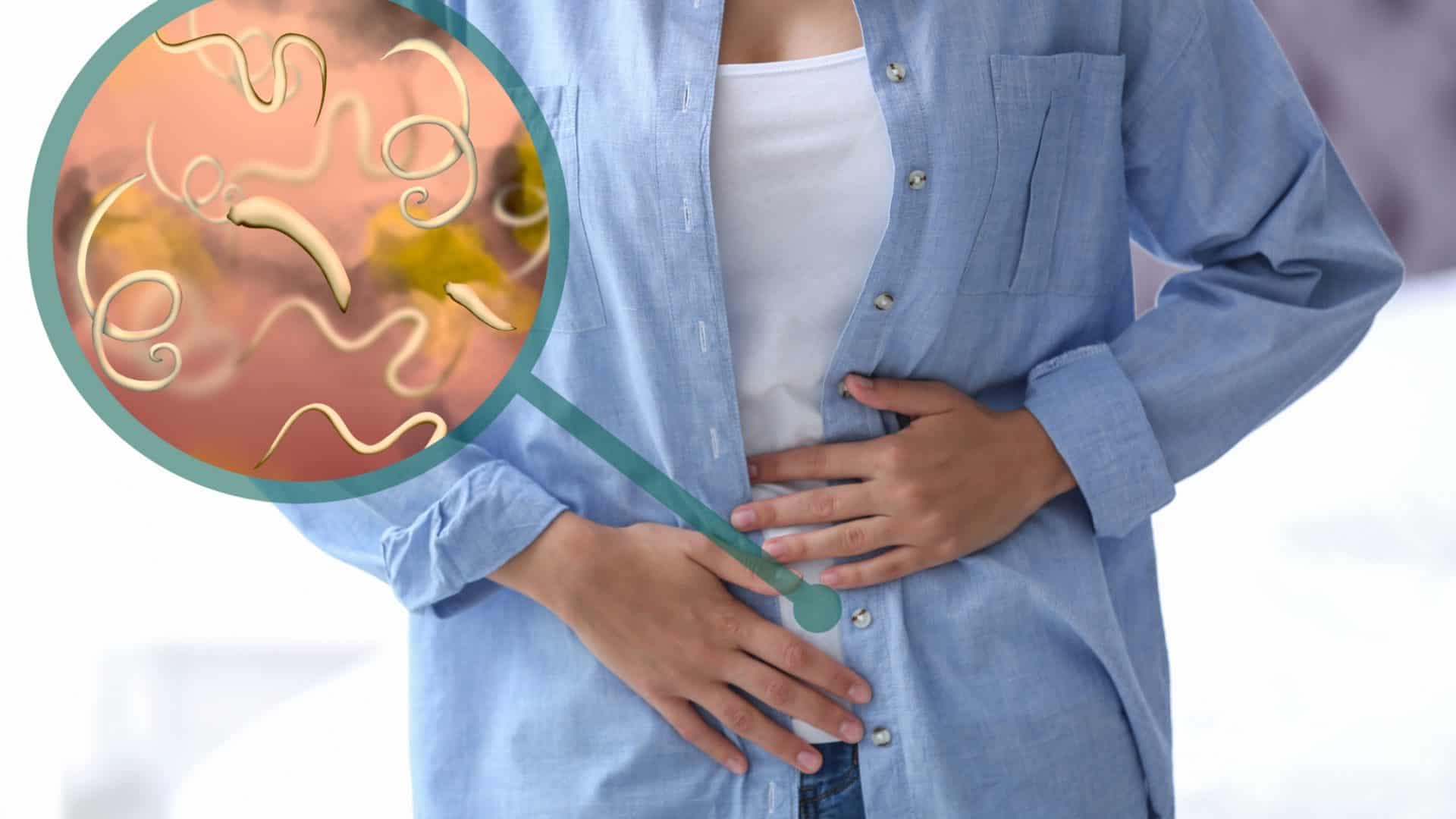 Parasitas sob microscópio e mulher com dor abdominal