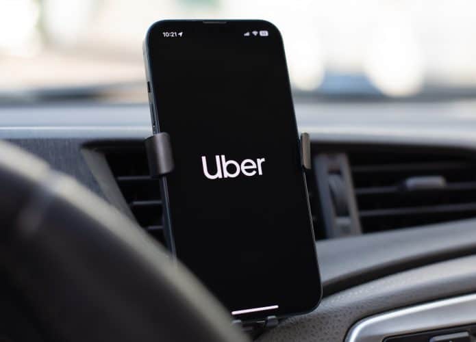 Logo da Uber em um smartphone preso no painel de um carro