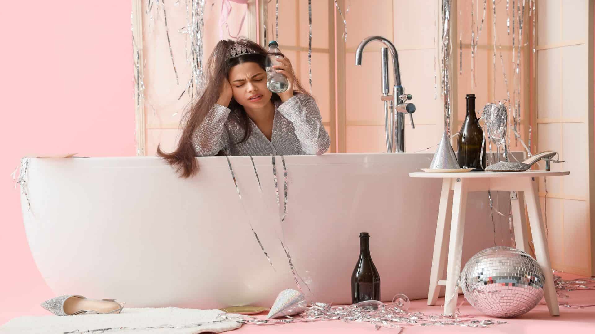 Mulher bêbada sofrendo de ressaca na banheira sobre fundo rosa