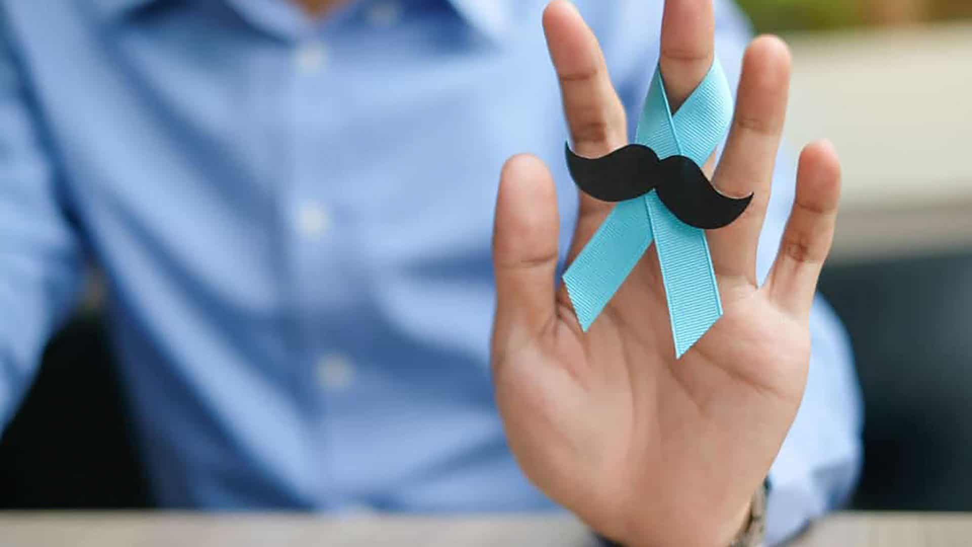 Homem segurando um laço azul com bigodes