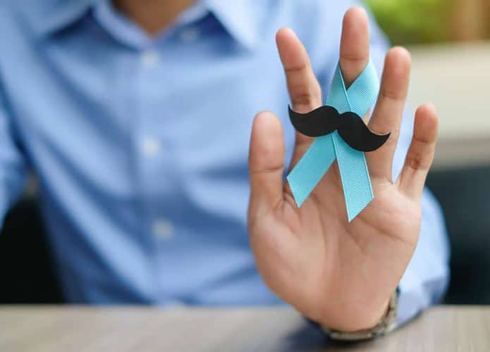 Homem segurando um laço azul com bigodes