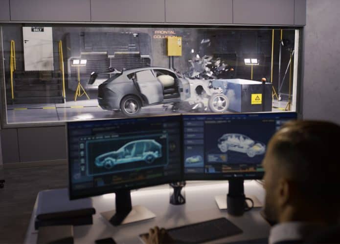 Homem olhando para monitores de computador durante teste de segurança de carro
