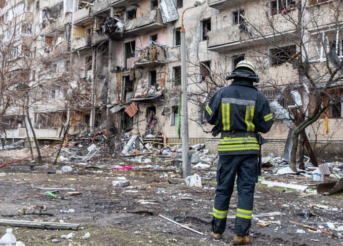 Bombeiro em frente prédios destruídos durante guerra na Ucrânia