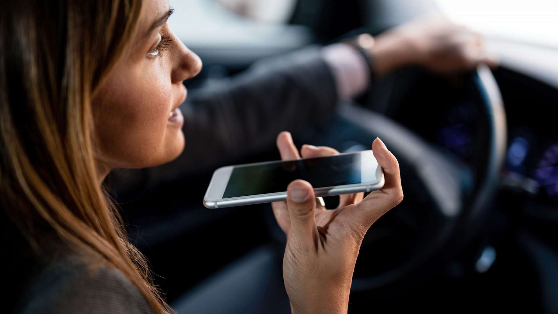 Mulher utilizando o celular enquanto dirige