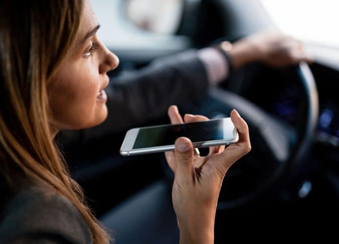 Mulher utilizando o celular enquanto dirige