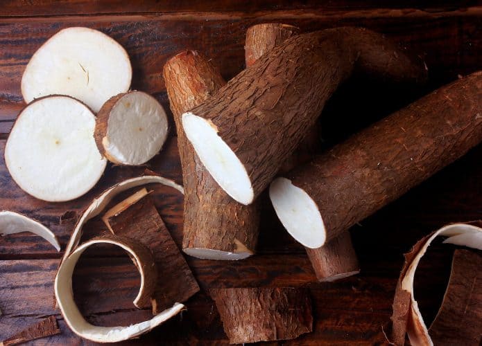 Mandioca crua em cima de tábua de cozinha
