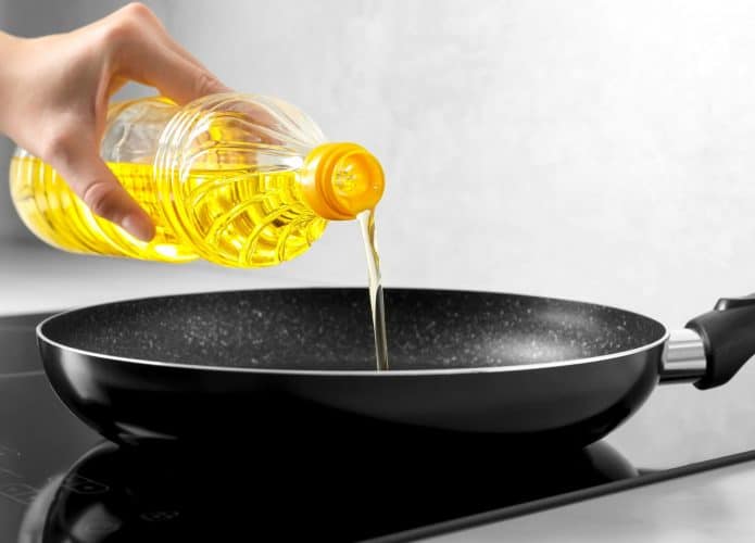 Óleo de cozinha sendo despejado em uma frigideira