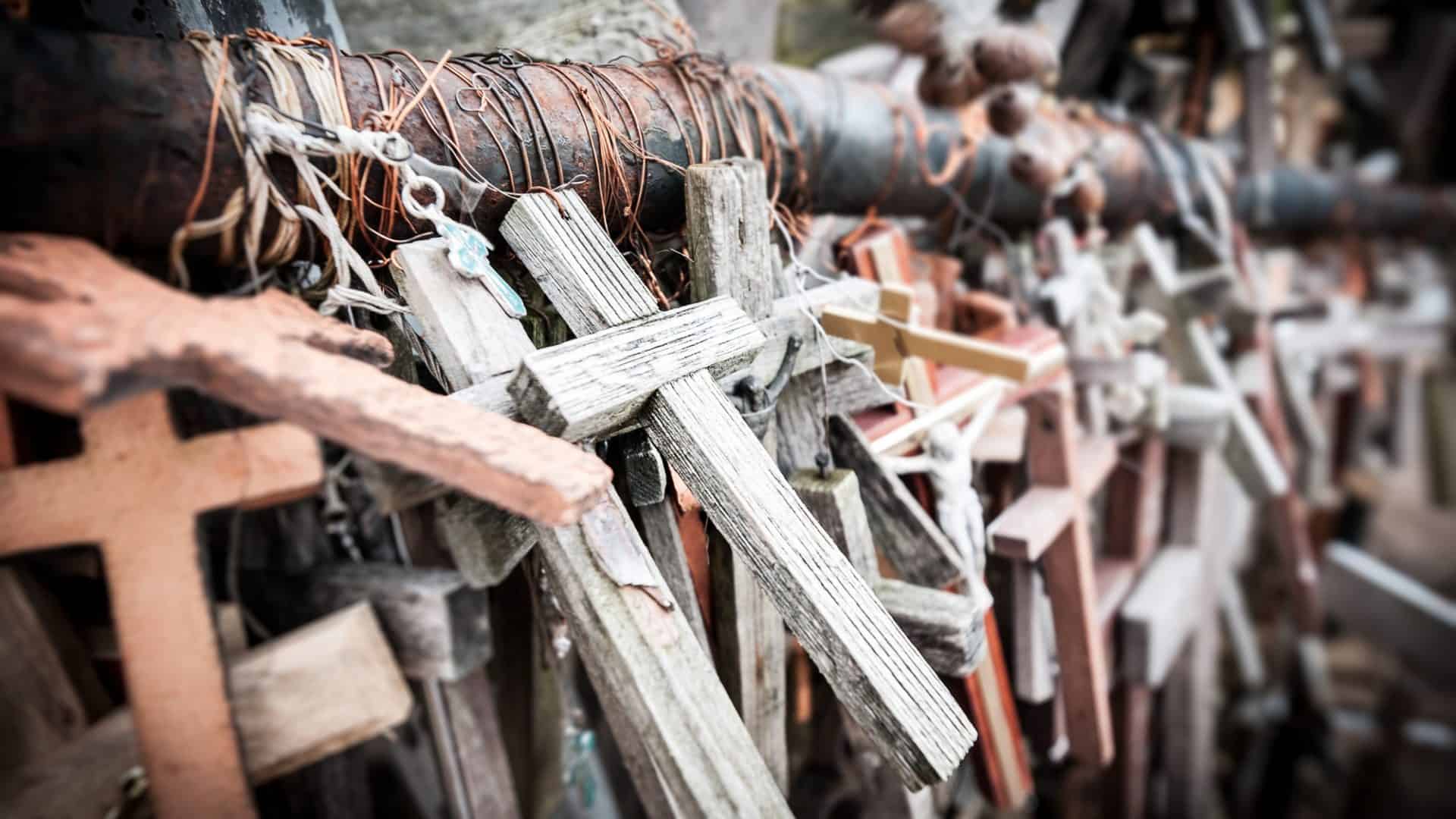 Muitas cruzes diferentes, a maioria de madeira amarrada para suporte como memorial. Composição de cruzes em memória dos mortos.