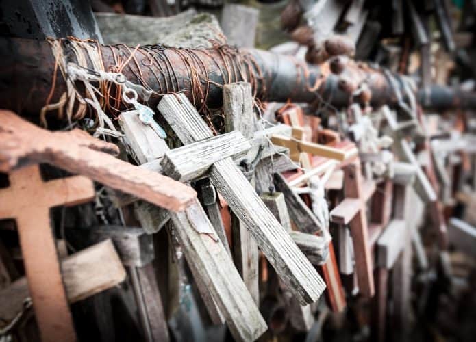 Muitas cruzes diferentes, a maioria de madeira amarrada para suporte como memorial. Composição de cruzes em memória dos mortos.