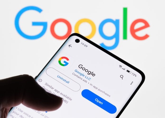 Pessoa com dedo sobre página do Google na Play Store num celular Android
