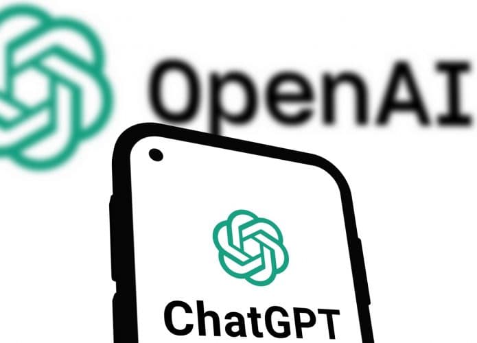 Logomarca do ChatGPT em tela de celular colocado na frente de imagem de logomarca da OpenAI