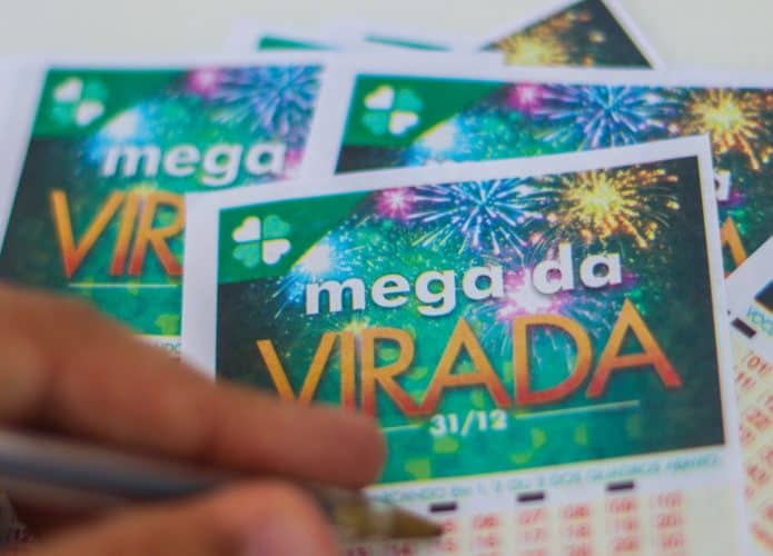 mão anotando números em cartão da mega da virada