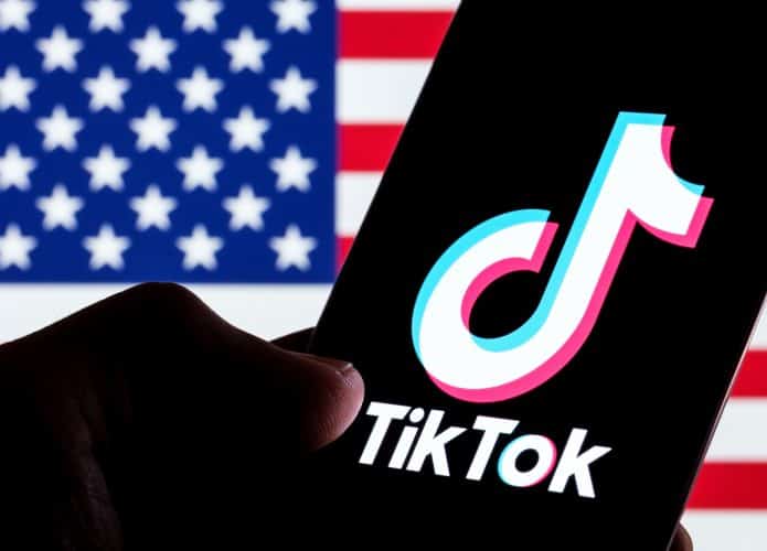Bandeira dos EUA à esquerda; à direita, logo do TikTok em um smartphone