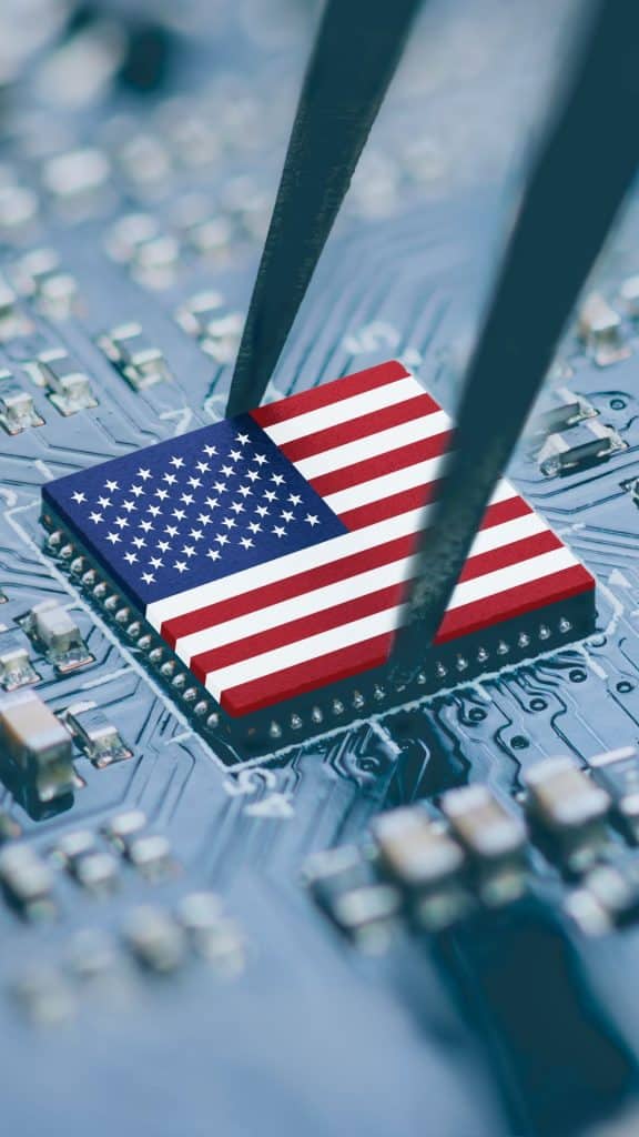 Pinça pegando chip com desenho da bandeira dos Estados Unidos