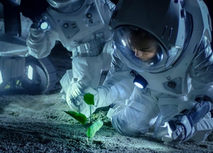 Astronautas vendo uma planta em crescer na Lua