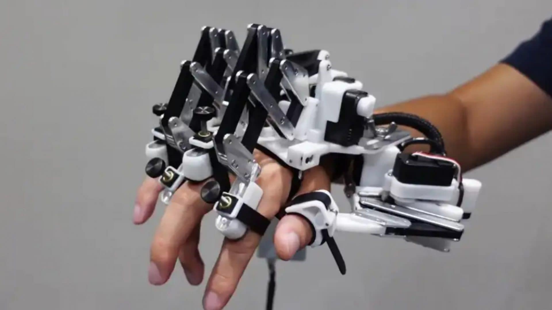 Mão robótica em cima de uma mão humana