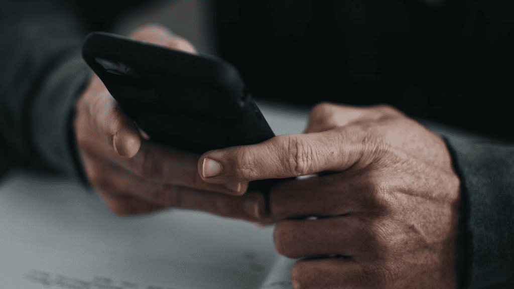 Pessoa segurando o celular com as duas mãos.