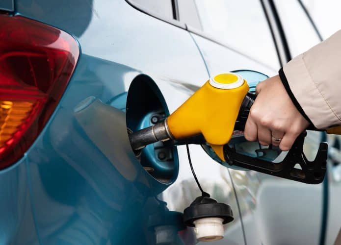 frentista abastecendo um carro com gasolina pela bomba de combustível