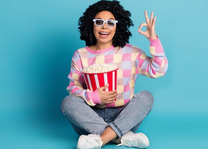 Foto corpo inteiro de atraente jovem mulher assistir filme ok vestido elegante rosa xadrez roupas isoladas no fundo cor azul
