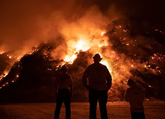 Bombeiros olhando para morros pegando fogo durante incêndios em Los Angeles em 2020