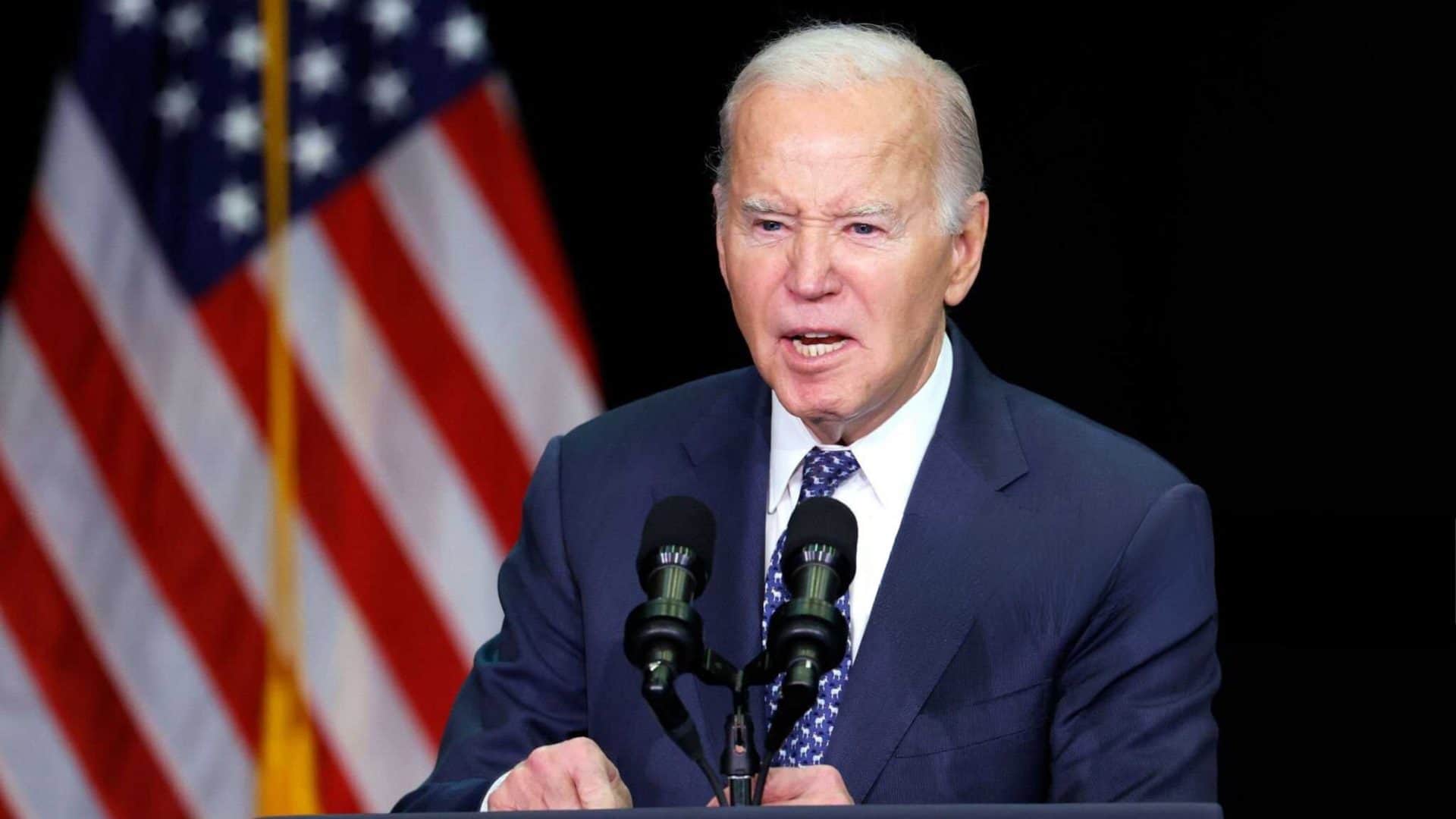 Joe Biden, na época presidente dos Estados Unidos, durante discurso em palanque com bandeira dos Estados Unidos no fundo