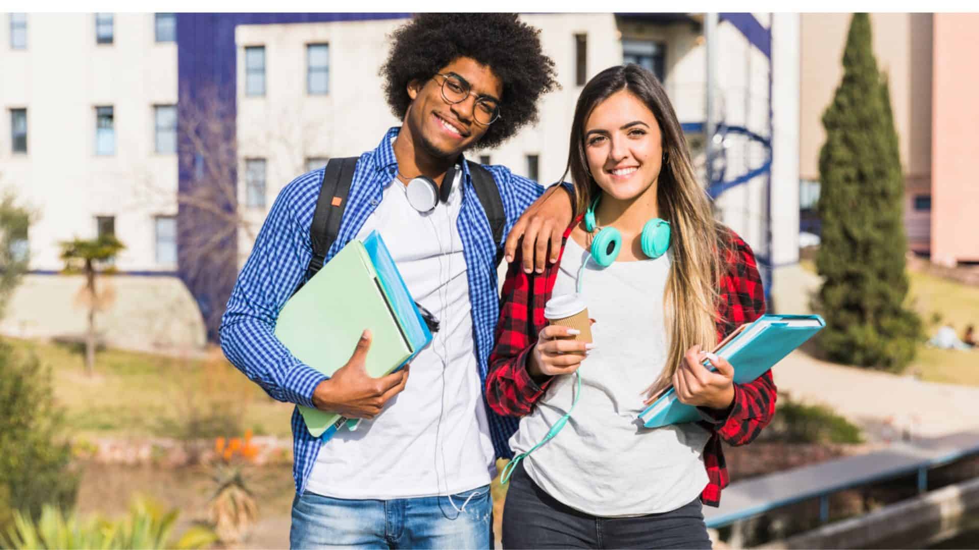 Um casal de estudantes lado a lado, segurando cadernos e com fones de ouvido