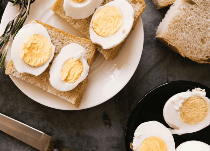 imagem mostra vários ovos cozidos numa refeição com fatias de pão