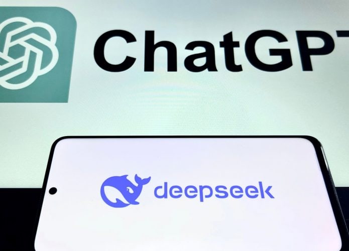Celular com logotipo da DeepSeek na tela colocado na frente de monitor exibindo logotipo do ChatGPT