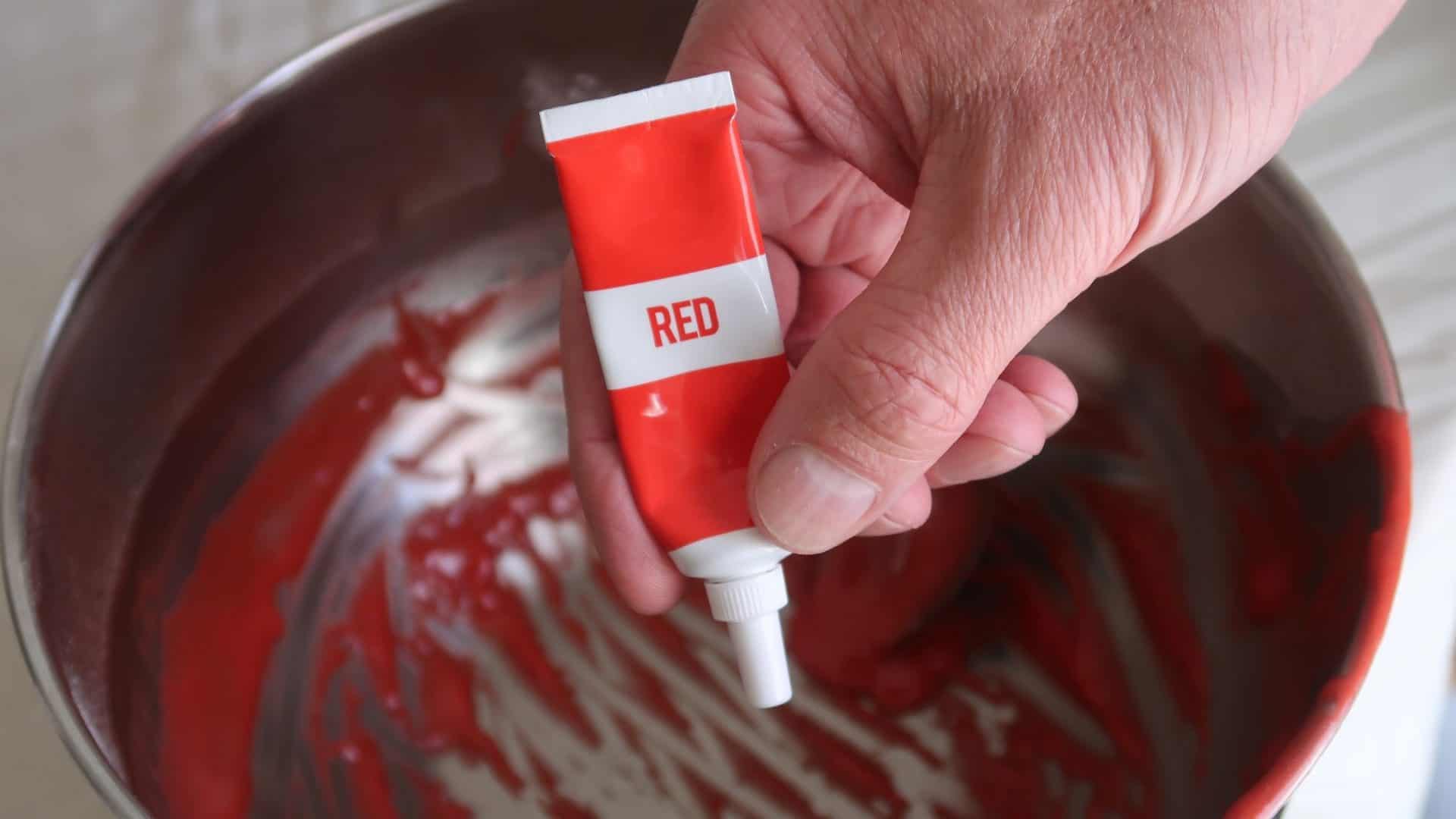 Corante vermelho em um tubo sendo despejado em uma panela