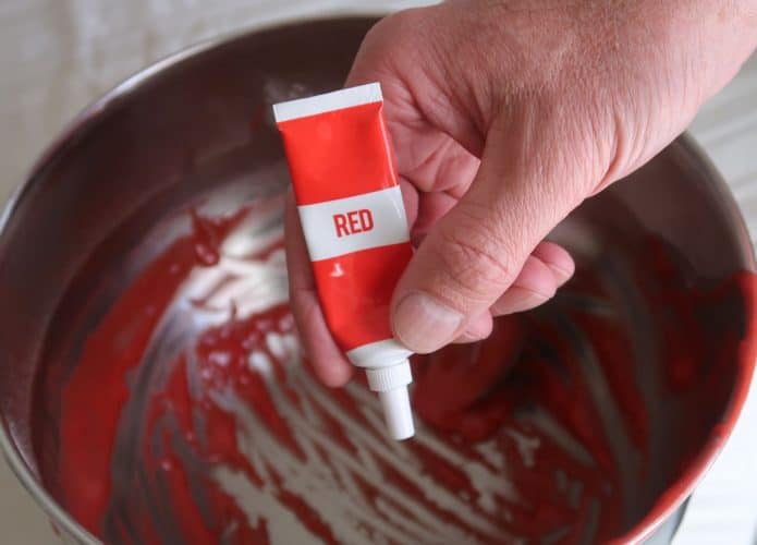 Corante vermelho em um tubo sendo despejado em uma panela