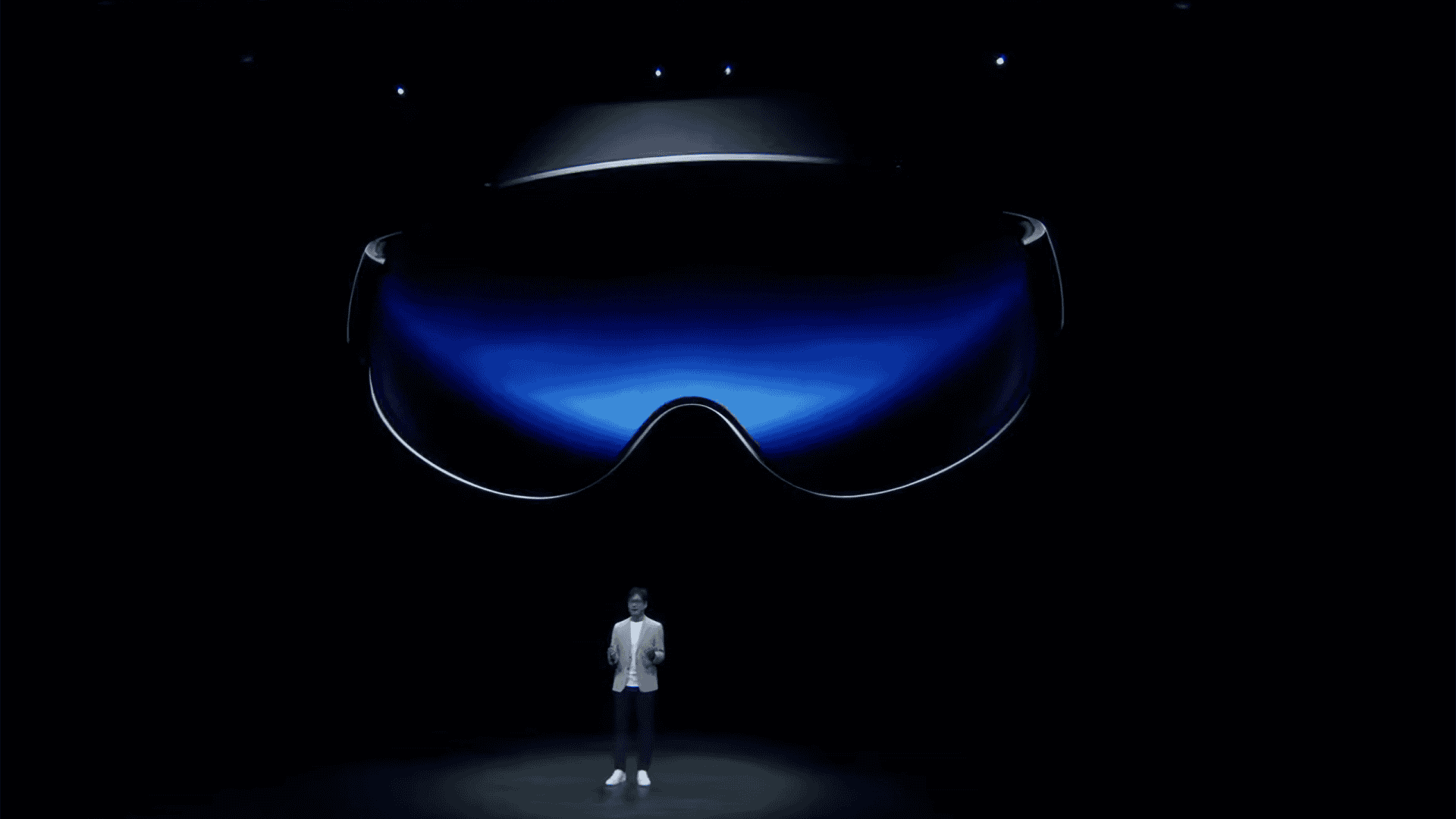 Ao fundo, em um telão, detalhe do headset da Samsung; À frente, um executivo da empresa falando