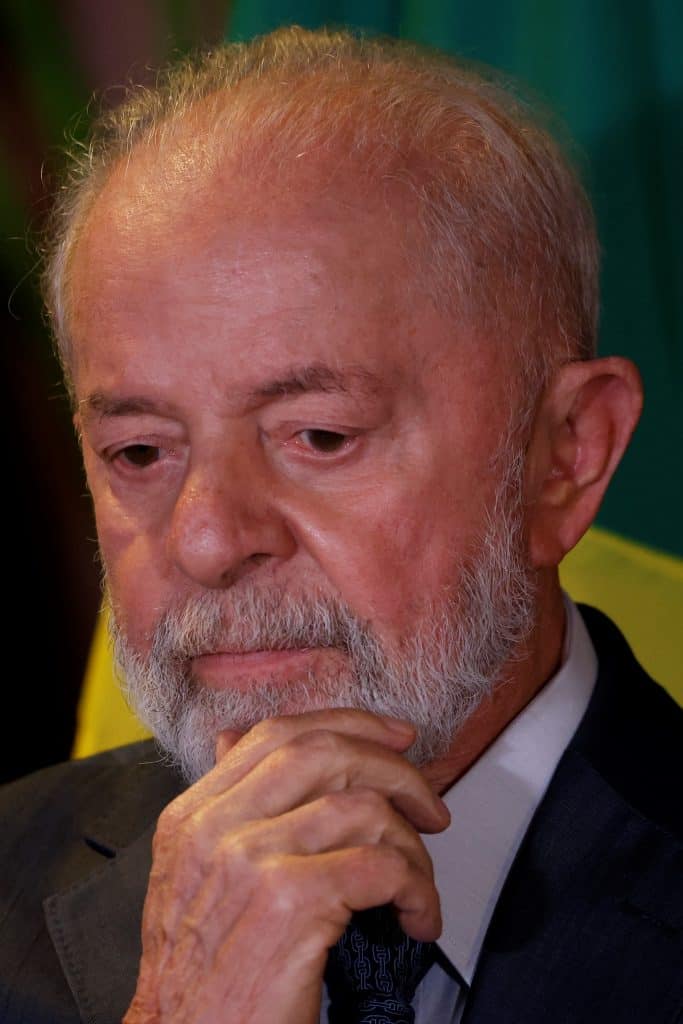 Lula olhando para baixo, com a mão no queixo, em estado pensativo