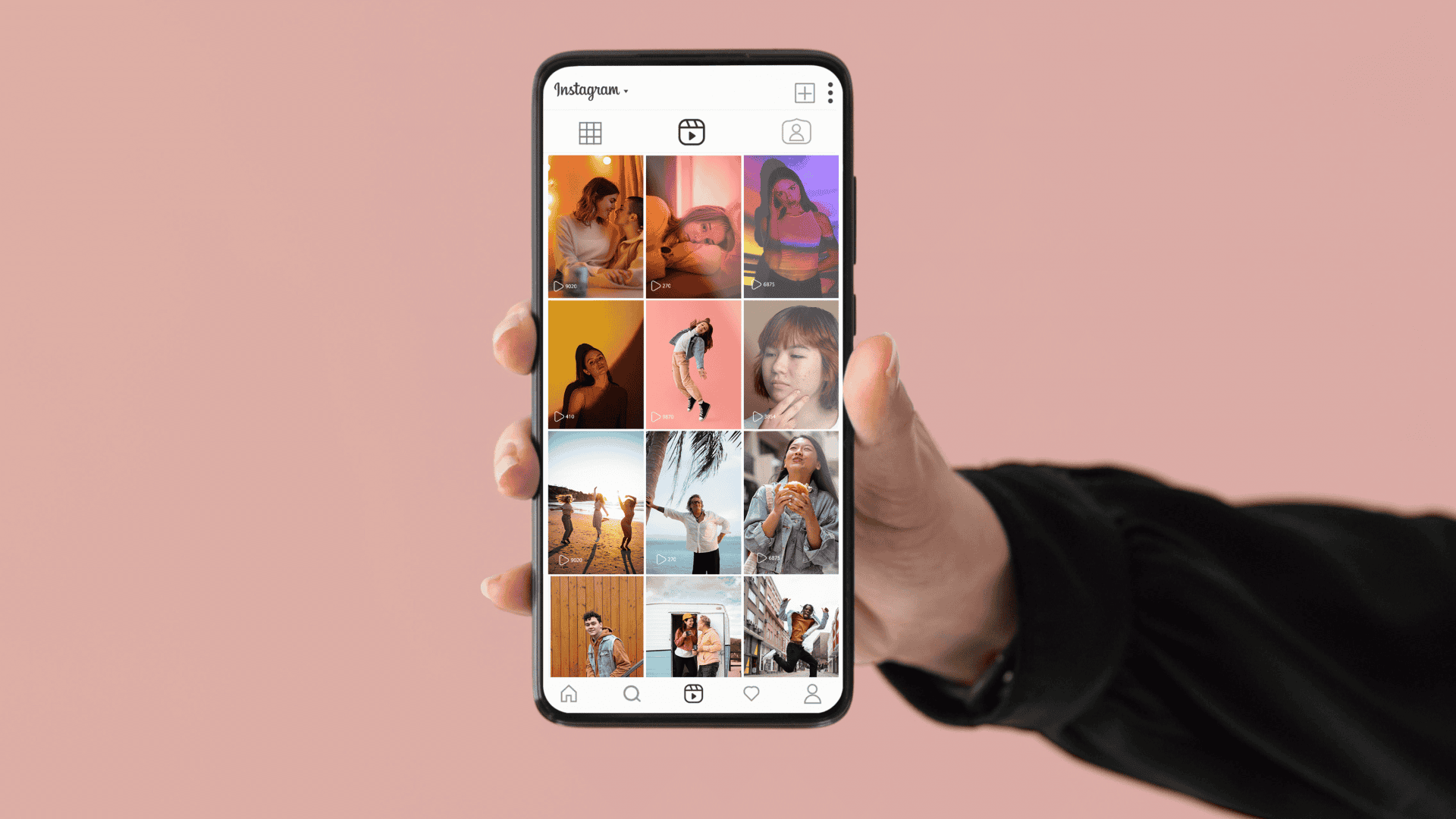 Mão segura um smartphone exibindo o perfil do Instagram, com miniaturas de postagens organizadas em formato vertical