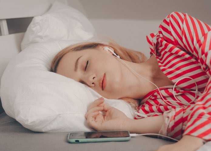 Mulher dormindo com fones de ouvido