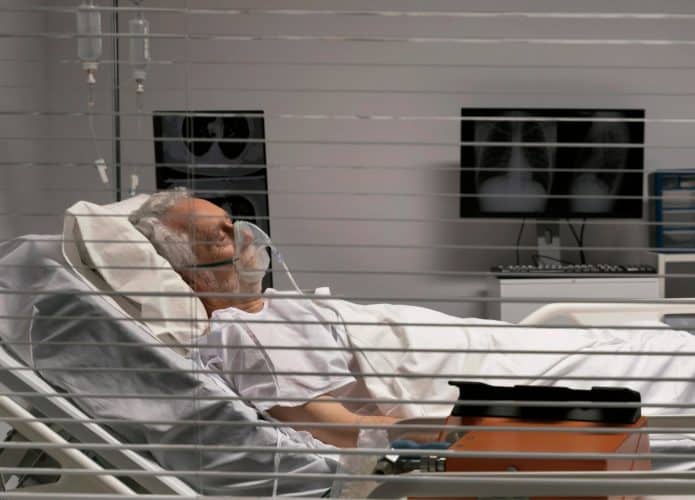 senhor em cama de hospital