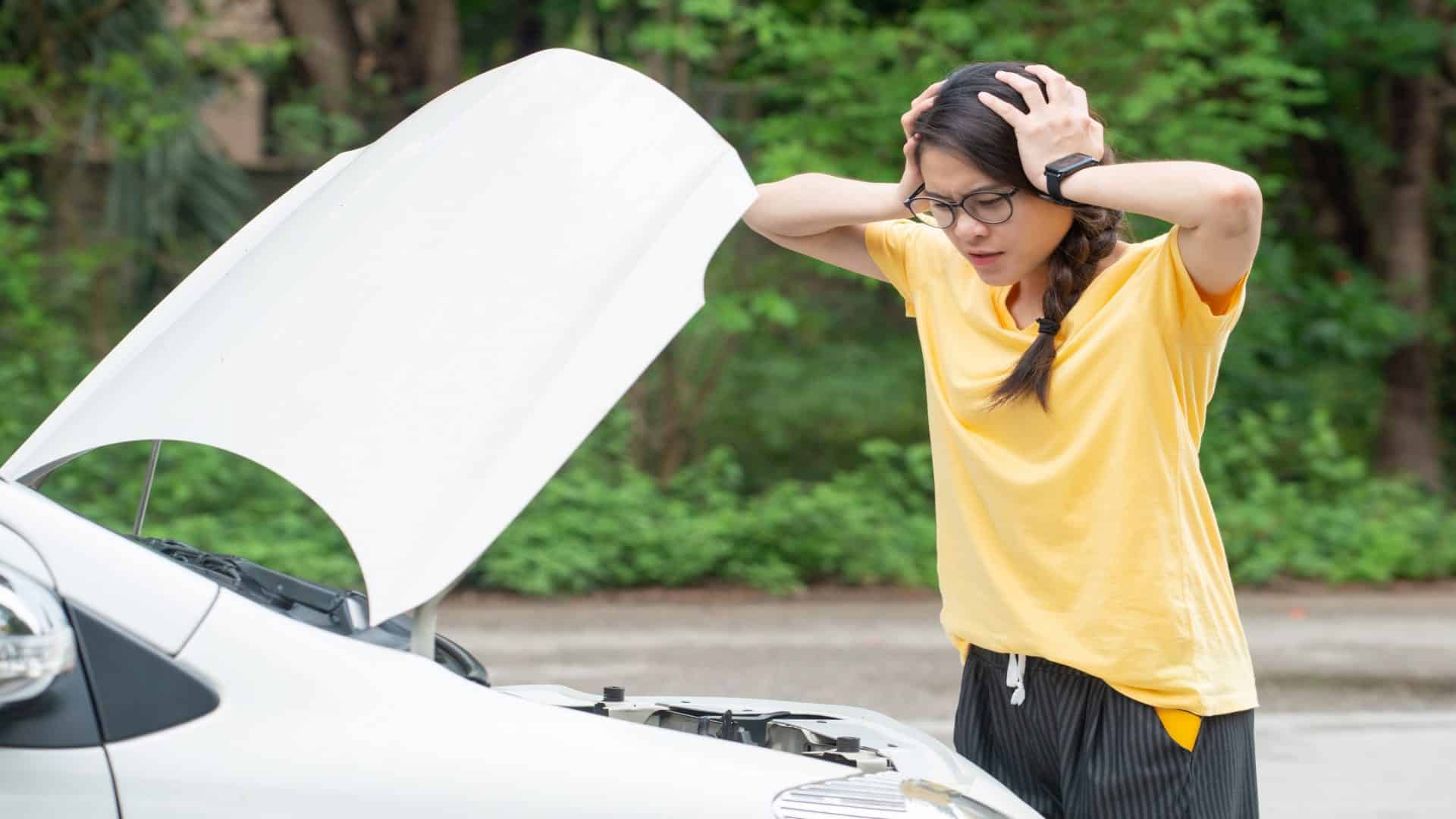 Jovem mulher estressada tendo problemas com a pane de seu carro na estrada e ela está esperando alguém que possa ajudá-la. Conceito de acidente de carro na estrada.